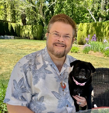 Dave sitting outdoors with his black pug